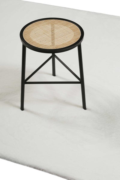 Runder Hocker mit Sitzfläche aus Rattangeflecht und schwarzem Metallgestell mit drei Beinen.