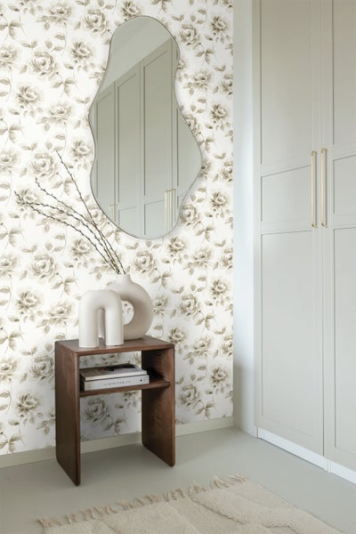 Raumansicht mit Blumentapete, Spiegel, Holzkonsole, Dekoration und Schrank