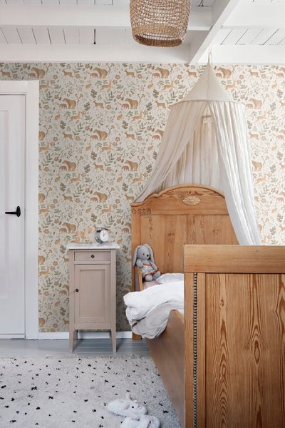 Kinderzimmer mit Waldtiermuster-Tapete, Bett, Nachttisch und Teppich