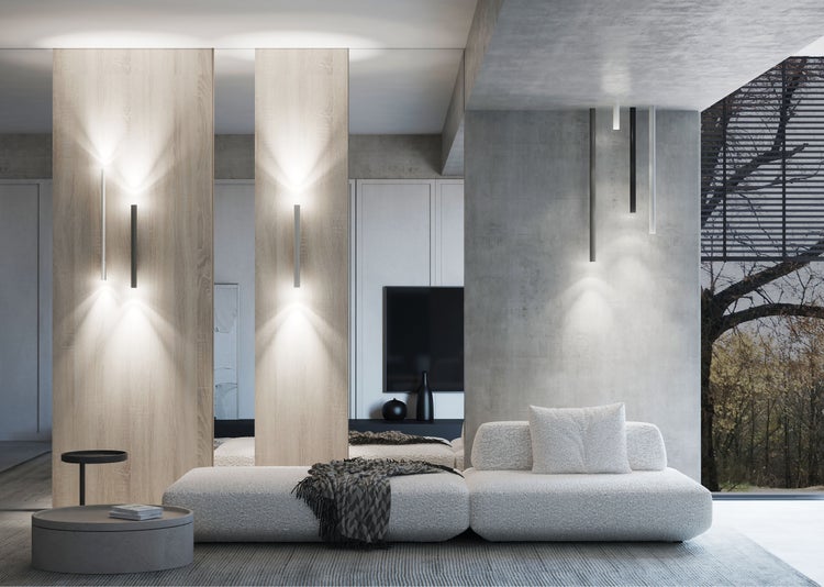 Moderner Wohnraum mit hellem Modulsofa, Wandleuchten auf Holzpaneelen, Sichtbetonwänden und einem flachen runden Couchtisch in Betonoptik.