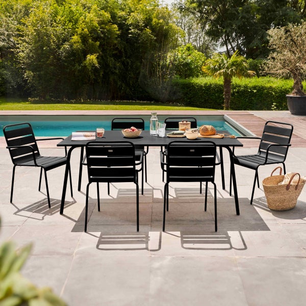 Modernes Gartenmöbel-Set bestehend aus einem schwarzen rechteckigen Tisch und sechs schwarzen Metallstühlen auf einer Terrasse neben einem Pool.