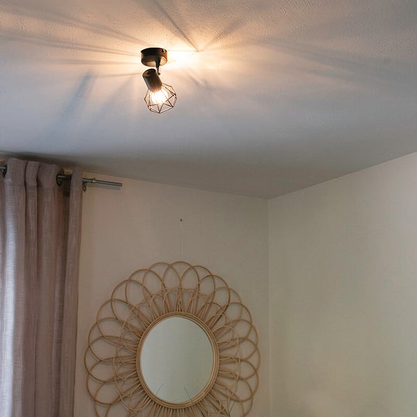 Deckenleuchte mit einem Strahler und einem runden Spiegel an der Wand.