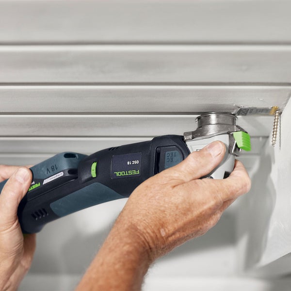 Eine Person benutzt ein oszillierendes Elektrowerkzeug von Festool, um an einer Decke zu arbeiten.