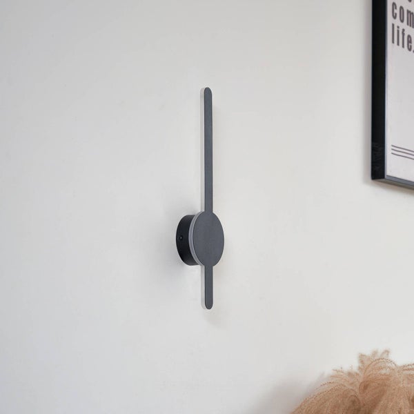 Moderne LED-Wandleuchte in Schwarz mit schmalem, vertikalem Stab und rundem Sockel.