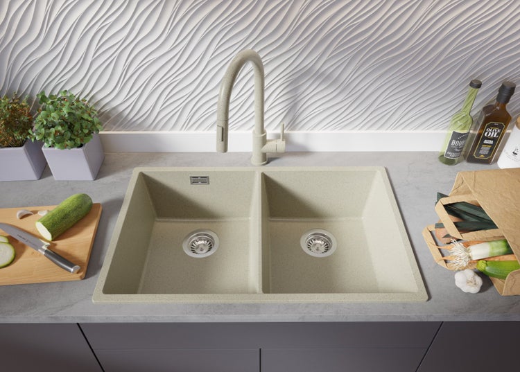 Spüle mit zwei Becken und passender Armatur, umgeben von Küchenutensilien und Lebensmitteln