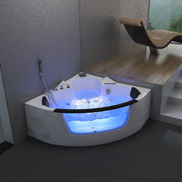 Eckbadewanne mit Whirlpoolfunktion und blauer Beleuchtung in einem modernen Badezimmer mit Holzpodest und Liege.