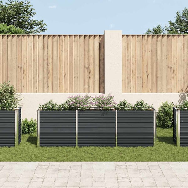 Modernes Hochbeet aus Metall in Anthrazit mit Pflanzen im Garten vor einem Holzzaun.