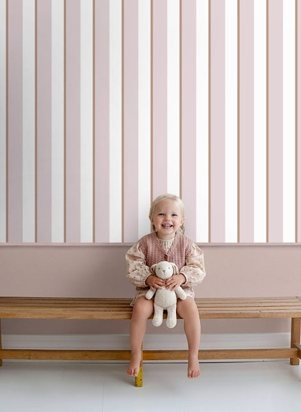 Zimmer mit gestreifter Tapete und Mädchen auf Holzbank