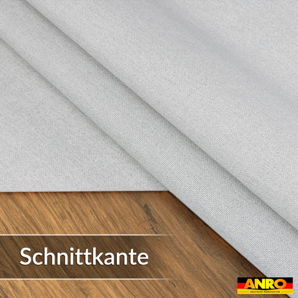 Stoff mit einer geraden Schnittkante auf einer Holzoberfläche, ANRO DEUTSCHE MANUFAKTUR Logo.