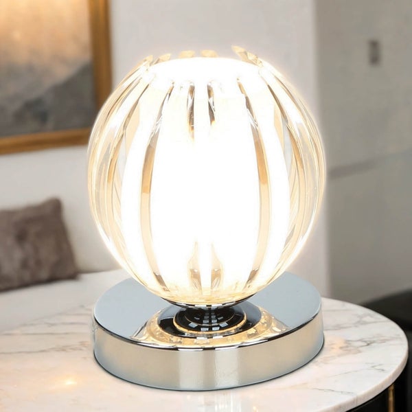Tischleuchte mit Kugel aus durchsichtigem Material und silberfarbenem Sockel