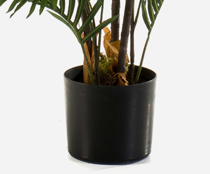 Künstliche Monstera Pflanze in einem goldenen Topf mit durchbrochenen Blättern.