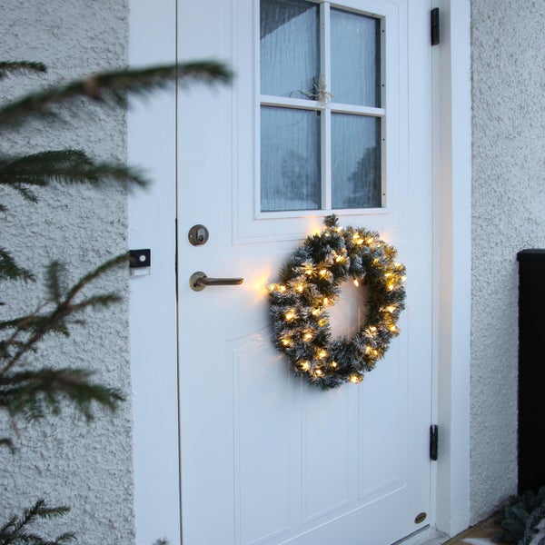 Weihnachtlicher Türkranz mit Beleuchtung an einer Haustür