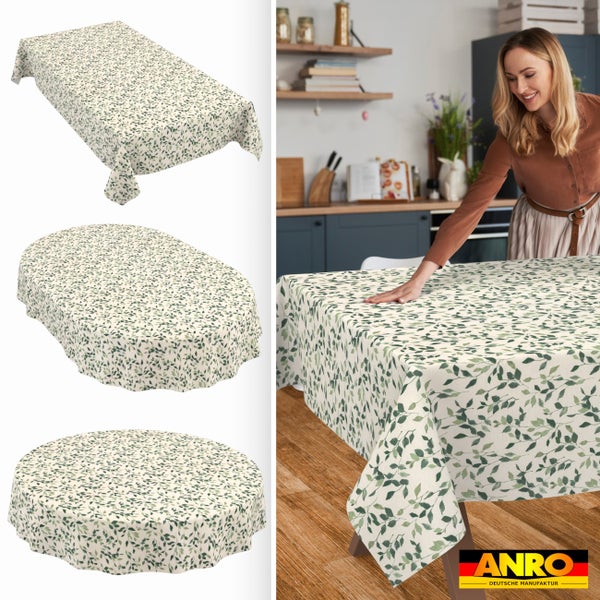 Tischdecke mit Blättermuster in rechteckiger, ovaler und runder Form in einer hellen Küche mit einer Frau. ANRO DEUTSCHE MANUFAKTUR Logo.