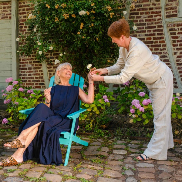 Rückansicht eines Adirondack-Gartenstuhls aus Holz in Türkis mit hoher Rückenlehne.
