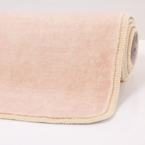 Weichflor-Teppich mit geketteltem Rand, teilweise eingerollt.