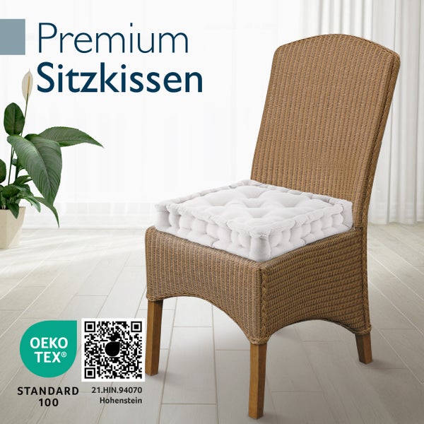 Ein Premium Sitzkissen auf einem Rattan Stuhl in einem hellen Raum mit Oeko Tex Standard 100 Zertifizierung.