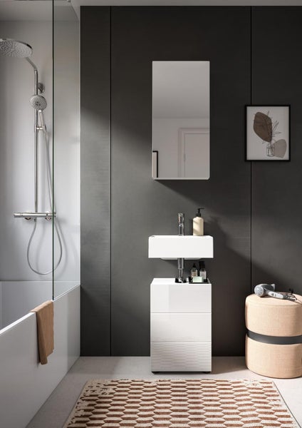 Modernes Badezimmer mit weißem Waschbecken, Unterschrank, Spiegelschrank und dunkelgrauer Wand.