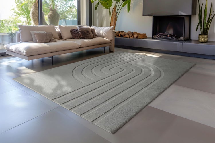 Moderner rechteckiger Teppich mit strukturiertem Wellenmuster in einem hellen Wohnzimmer mit Sofa und Kamin.