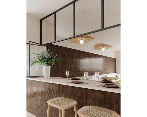Moderner Gastronomiebereich mit glänzenden braunen Wandfliesen in Riemchenoptik an der Theke und Rückwand sowie hellen Pendelleuchten.