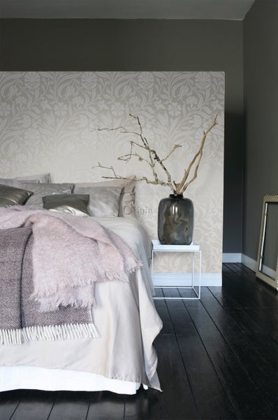 Schlafzimmer mit Bett, Tapete mit Blumenmuster und dekorativer Vase auf einem Beistelltisch