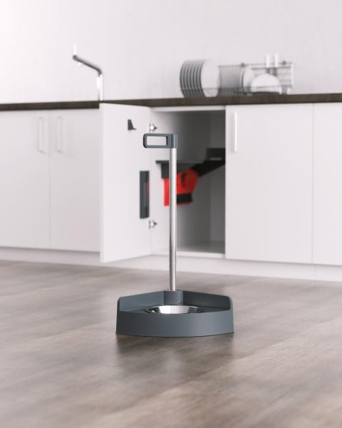 Ergonomischer Futternapf mit langem Griff und Edelstahlschale auf einem Boden in Holzoptik in einer hellen, modernen Küche.