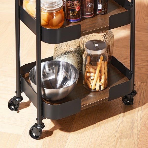 Servierwagen mit verschiedenen Gegenständen auf Holzregalen und Rollen