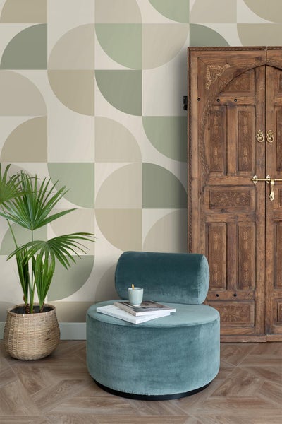 Wohnraum mit geometrischer Tapete, Sessel und Holztür