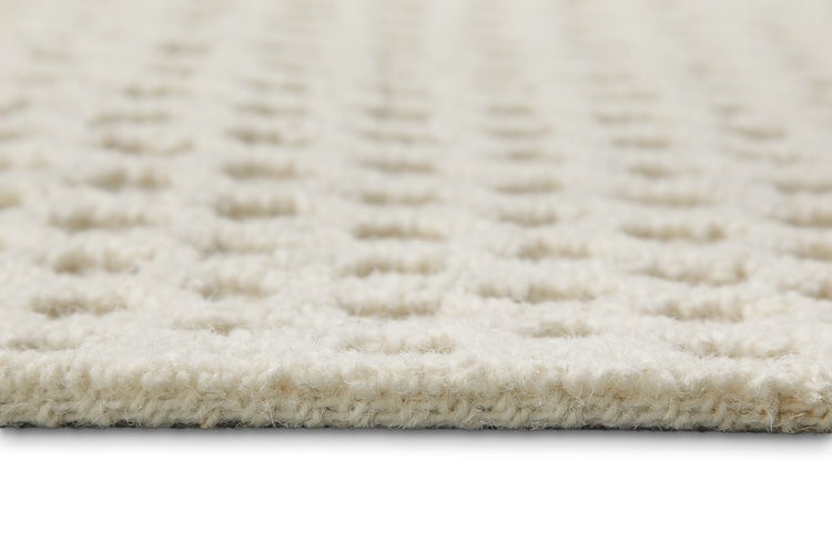 Nahaufnahme eines Teppichs mit geometrischem Muster und getuftetem Flor.