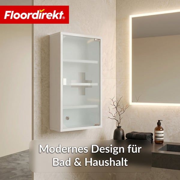 Abschließbarer Medizinschrank mit Glastür und Kreuz-Symbol in einem modern eingerichteten Badezimmer mit beleuchtetem Spiegel. Floordirekt Logo.