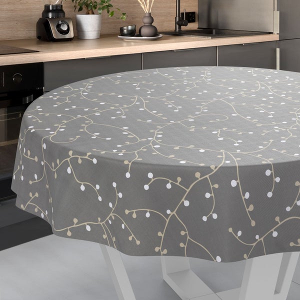Runde Tischdecke mit Zweigmuster auf einem Tisch in einer modernen, organisierten Küche mit Arbeitsplatte in Holzoptik.