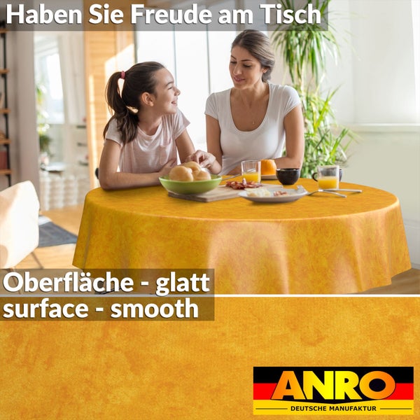Eine Mutter und ihre Tochter an einem runden Tisch mit einer glatten, marmorierten, gelben Tischdecke. ANRO DEUTSCHE MANUFAKTUR Logo.