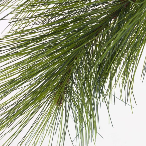Künstlicher Kiefernzweig mit langen grünen Nadeln.