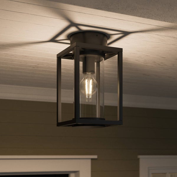 Schwarze Deckenleuchte für den Außenbereich in Laternenform mit klarem Glaszylinder und leuchtendem LED-Leuchtmittel an einer Holzdecke.