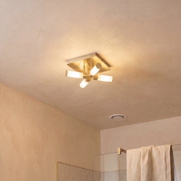 Moderne 4-flammige Deckenleuchte in Messing-Optik an einer Badezimmerdecke neben einer Duschwand aus Glas.