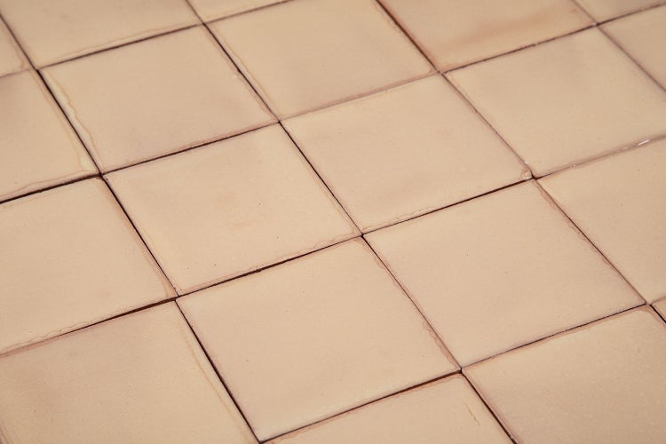 Quadratische Bodenfliesen aus Terrakotta, verlegt.