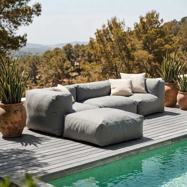 Grauer Outdoor-Sitzsack auf einer Holzterrasse an einem Pool.