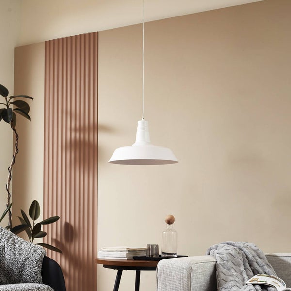 Weiße Pendelleuchte im modernen Wohnzimmer über einem Beistelltisch neben einem Sofa und einer Pflanze.