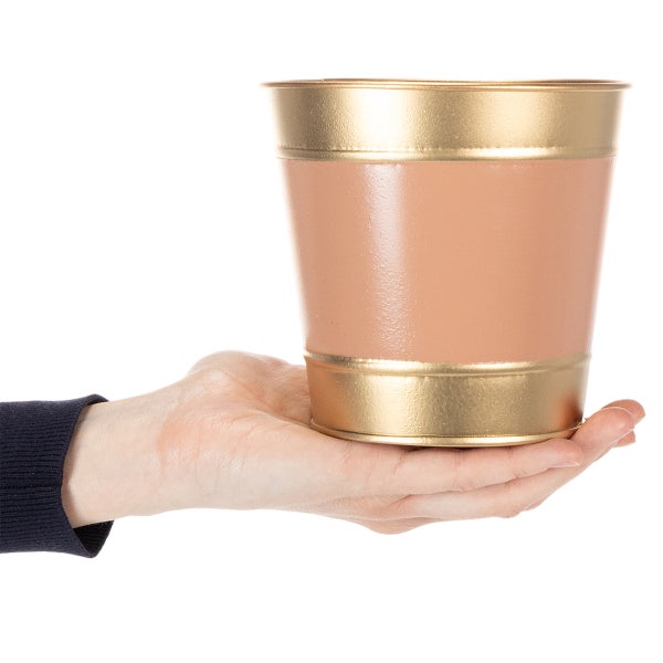 Kleiner Übertopf aus Metall im zweifarbigen Design, auf einer Hand gehalten zur Größendarstellung.