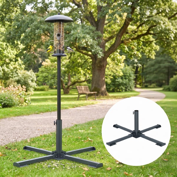 Metallständer für Vogelfutterstation mit Kreuzfuß und Futtersäule in einem weitläufigen, hellen Garten mit Bäumen und Parkbank.