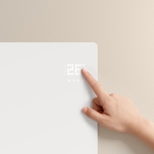 Eine Person bedient einen Heizkörper mit Digitalanzeige.