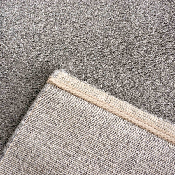 Nahaufnahme eines Teppichbodens mit feiner Schlingenstruktur und sichtbarem gewebtem Teppichrücken.