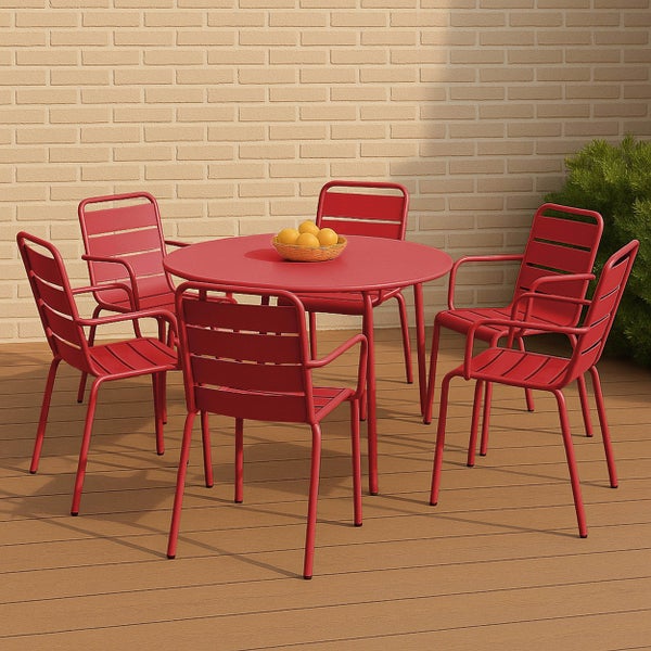 Runder Gartentisch mit fünf Armlehnenstühlen aus Metall in Rot auf einer Holzterrasse vor einer hellen Ziegelwand.