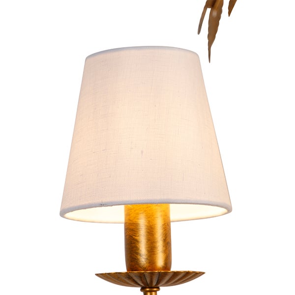 Nahaufnahme einer goldenen Leuchte mit weißem Lampenschirm.