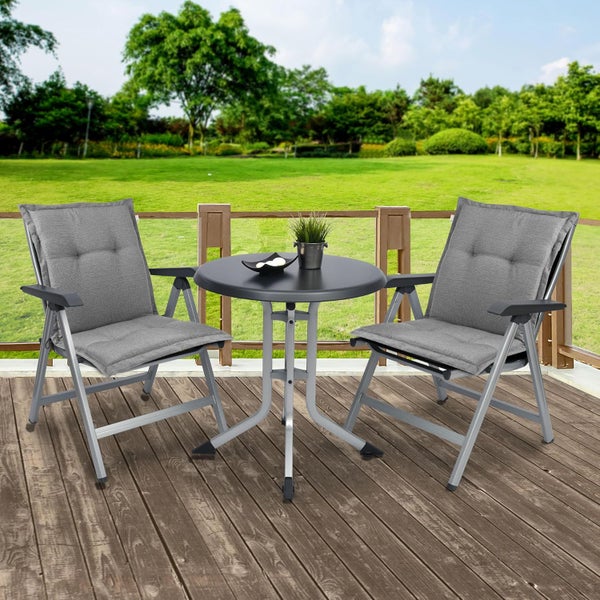 Modernes dreiteiliges Gartenmöbel-Set aus Metall mit zwei grauen Klappstühlen inklusive Polstern und einem runden Tisch auf einer Holzterrasse.