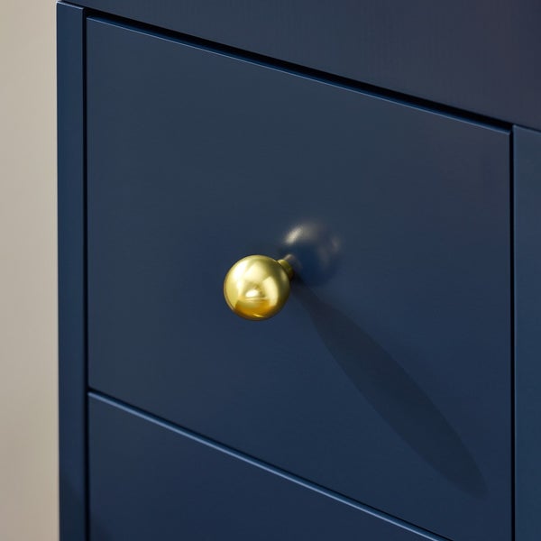 Detailaufnahme eines blauen Schubladenelements mit goldenem, kugelförmigem Griff