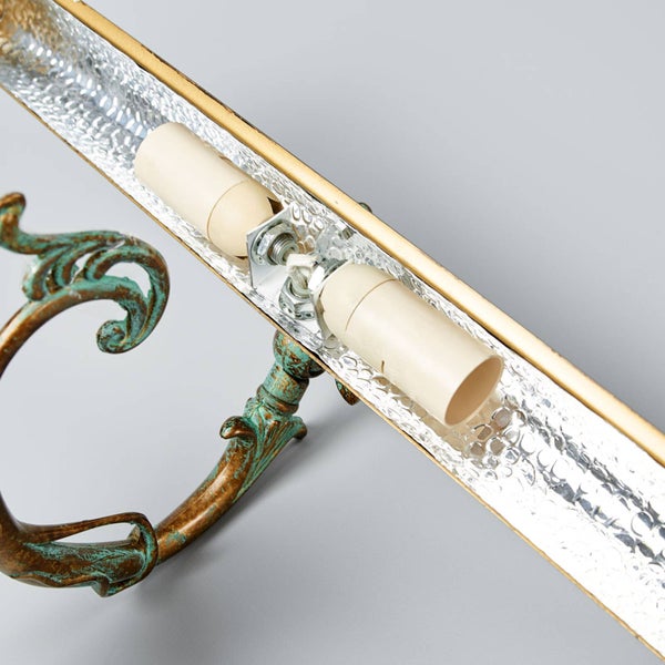 Detailansicht einer Wandleuchte mit zwei Fassungen und verzierter Halterung