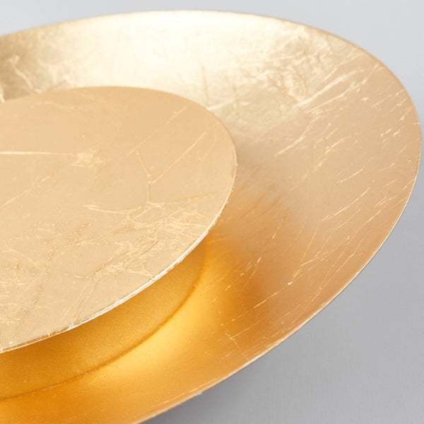 Detailansicht einer runden Wandleuchte aus zwei goldfarbenen Scheiben mit strukturierter Schlagmetall-Optik.