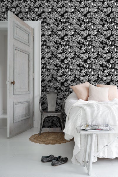 Schlafzimmer mit gemusterter Tapete, Bett und Tür