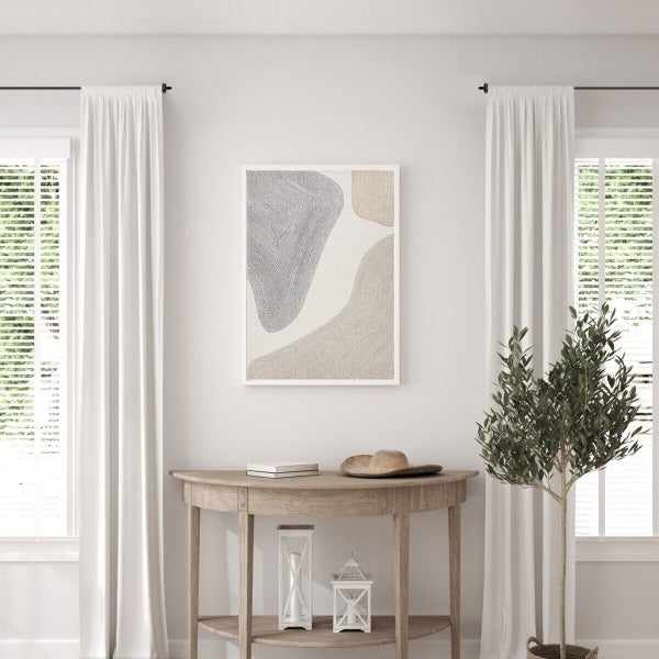 Wandbild mit abstrakten Formen in einem hellen Flur mit Holztisch und Pflanze vor Fenstern mit weißen Vorhängen