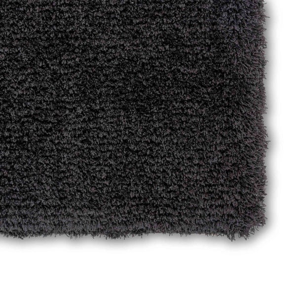 Detailansicht eines anthrazitfarbenen Hochflor-Teppichs mit weicher, zotteliger Struktur.